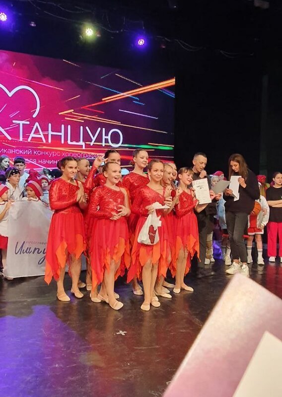 Девочки в красных платьях на сцене