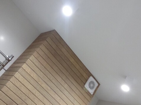 Белый матовый потолок со встроенными точечными светильниками и декоративной лентой вставкой по периметру