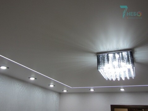 Белый матовый потолок со световой линией, точечными светильниками и люстрой