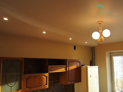 Белый уровневый потолок со встроенными софитами и люстрой для зонирования кухни фото и проекты