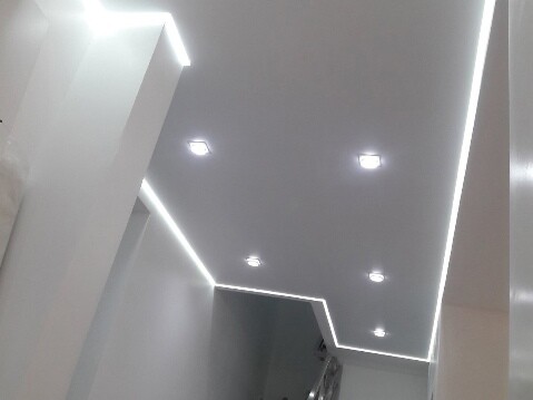 Белый матовый потолок с точечными светильниками с рассеиванием света в разных тонах