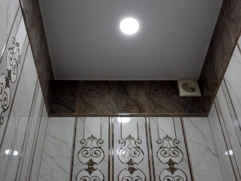 Белый зеркальный, лаковый, глянцевый потолок со встроенными точечными светильниками и декоративной лентой вставкой по периметру
