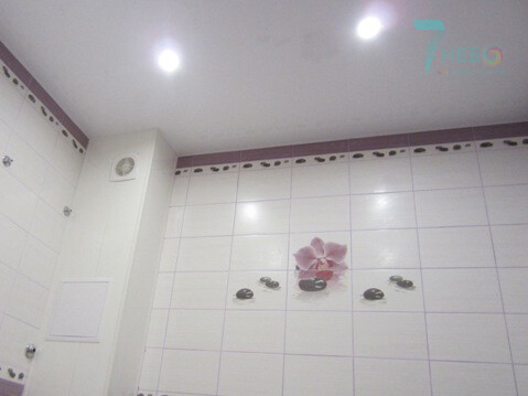 Белый сатиновый потолок со встроенными точечными светильниками и декоративной лентой вставкой по периметру