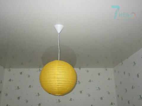 Фото белый лаковый потолок в детскую комнату с желтой люстрой в виде шара